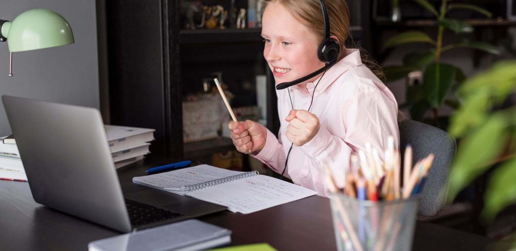 plataformas para aulas online: imagem de uma criança feliz em frente a um computador