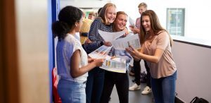 como-fidelizar-alunos-na-escola: imagem de alunas do ensino médio comemorando resultados obtidos