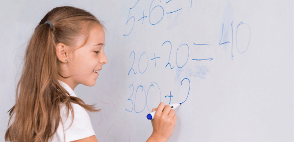Métodos de avaliação: imagem uma aluna fazendo cálculos matemáticos no quadro.