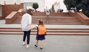 Como fazer uma boa captação de alunos: criança chegando à escola acompanhada da mãe