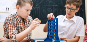 Gamificação na educação: imagem de dois alunos concentrados em um jogo em sala de aula.