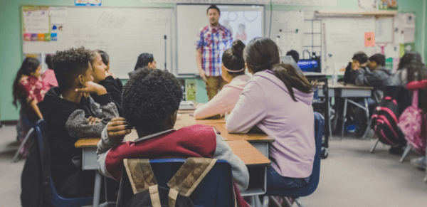 Janeiro Branco: imagem de um professor na frente da sala de aula falando para seus alunos.