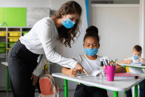 Acolhimento dos alunos: professora ajudando aluna a realizar uma tarefa