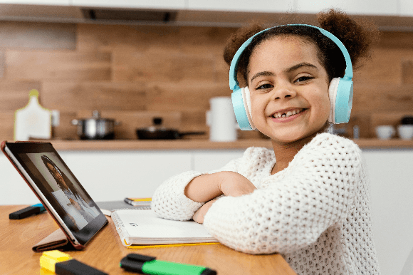 Tecnologias como ferramentas de aprendizagem: criança sorridente durante aula remota