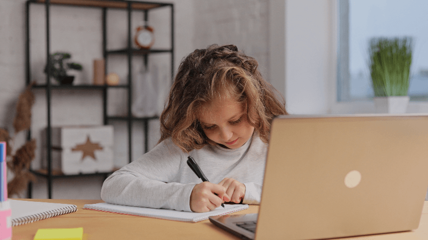 O papel da tecnologia na educação: imagem de uma menina estudando em casa com o computador