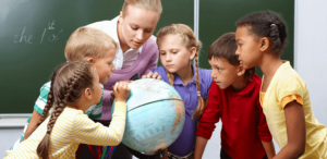 O que é aprendizagem personalizada: imagem de uma professora ensinando sobre o globo terrestre próxima de seus alunos
