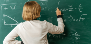 Aprendizagem significativa: imagem de uma professora de matemática escrevendo no quadro da sala de aula.