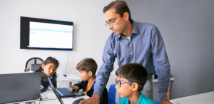 Transformação digital na educação: imagem de um professor ensinado seus alunos no laboratório de informática