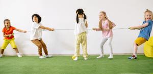 Atividades lúdicas: imagem com 5 crianças brincando de cabo de guerra